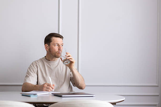 Focused person drinking water at a workspace